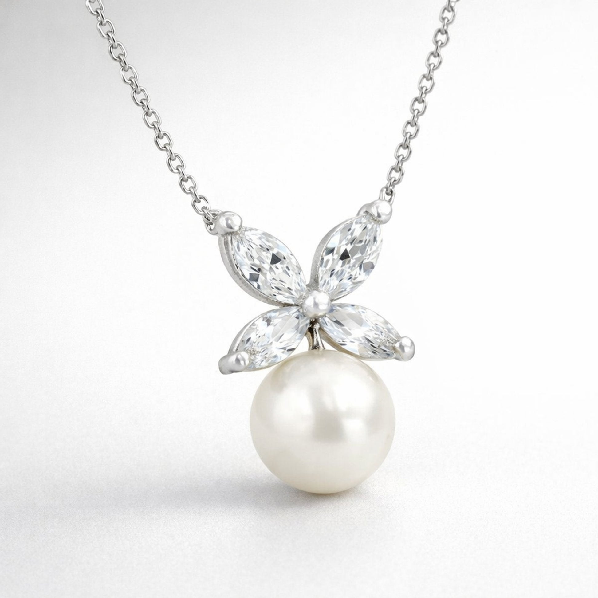 Detail view of the butterfly pendant highlighting the marquise cut cubic zirconia wing design and the smooth round pearl drop.