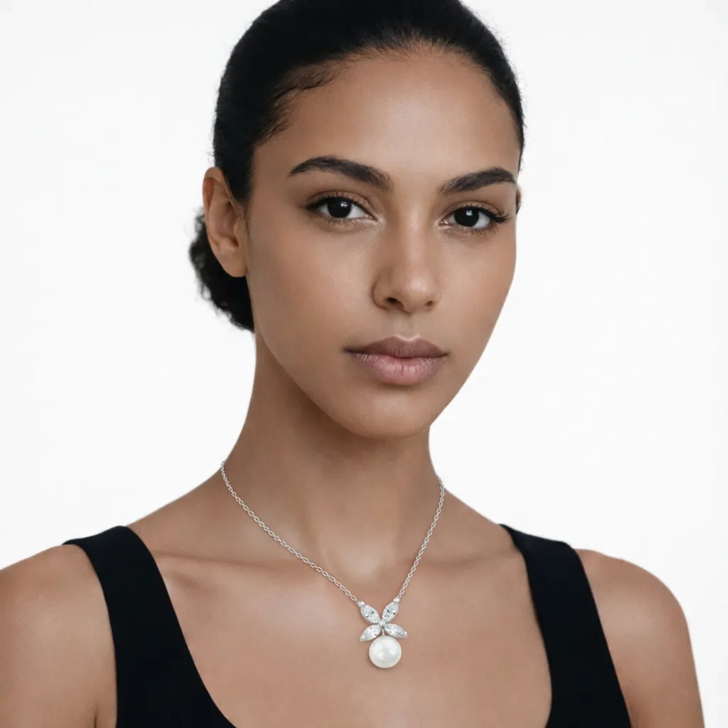 On-model portrait highlights a butterfly cubic zirconia and pearl pendant, styled with a black scoop-neck top so the pendant stays centered at the neckline.