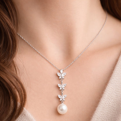 Worn view of the butterfly drop cubic zirconia and pearl pendant illustrating length, proportions, and movement.