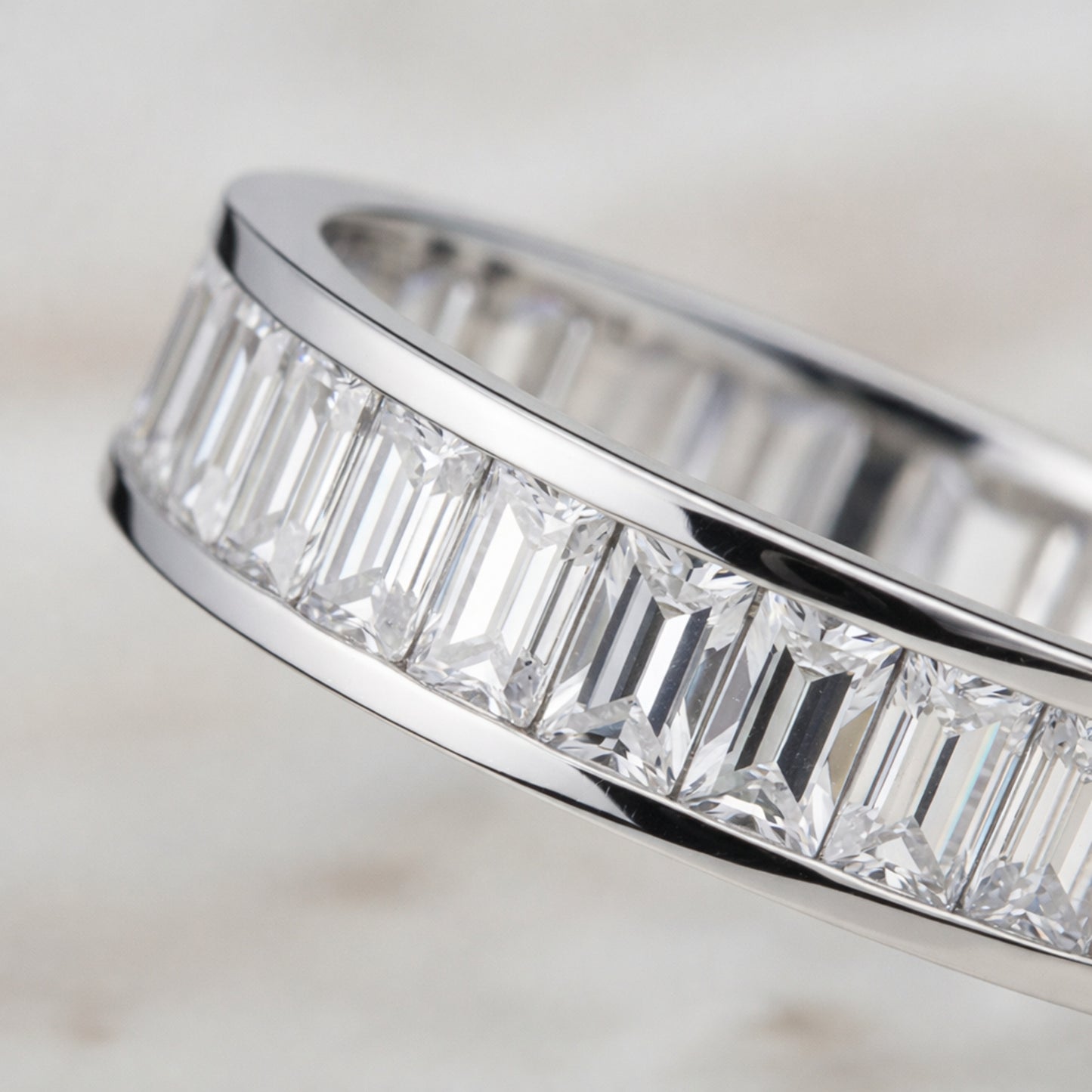 Angled view of the channel set baguette cut cubic zirconia ring emphasizing the straight baguette cut stones and smooth silver tone finish.
