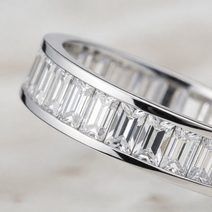 Angled view of the channel set baguette cut cubic zirconia ring emphasizing the straight baguette cut stones and smooth silver tone finish.