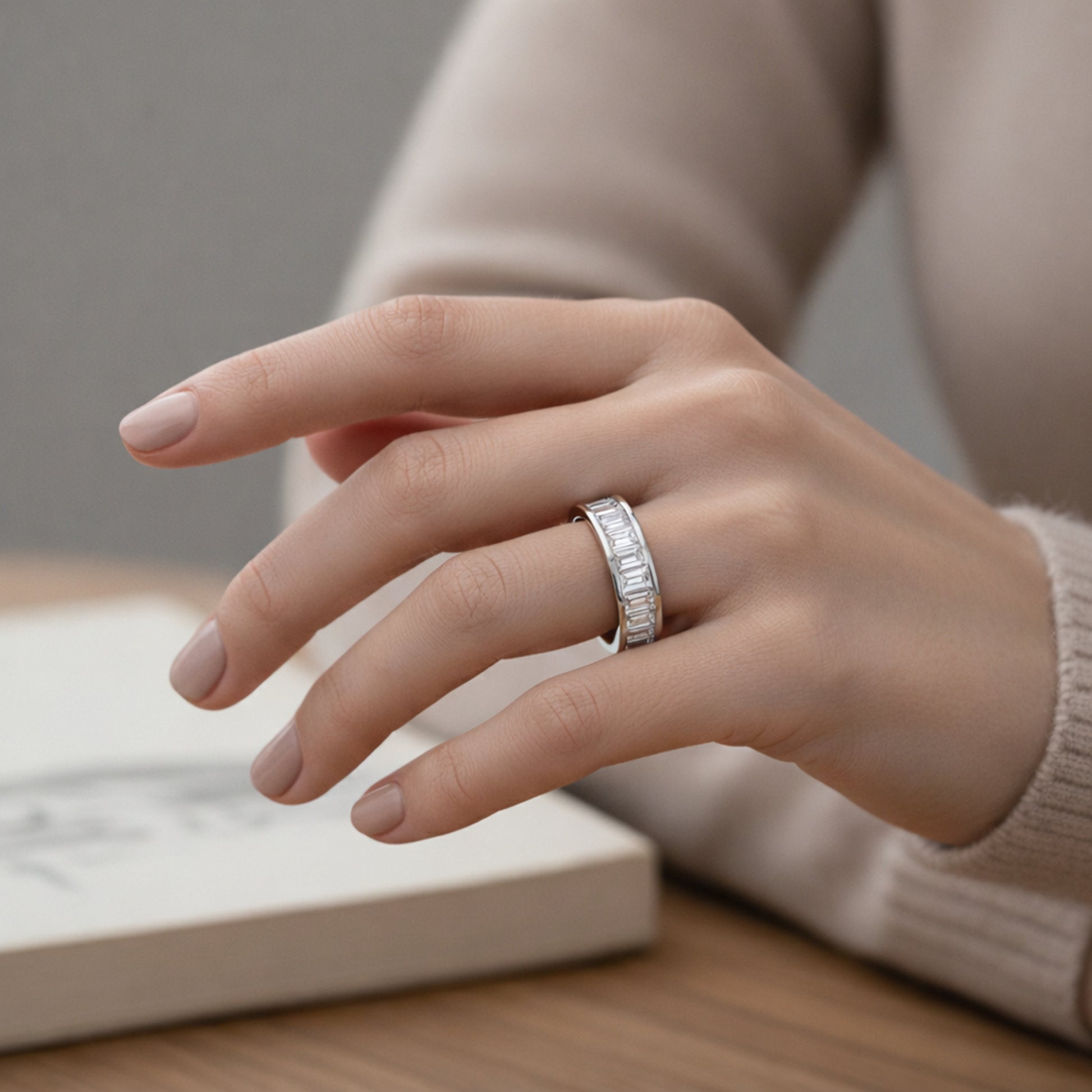Worn on hand view of a channel set baguette cut cubic zirconia ring in silver tone finish, illustrating proportions and everyday wear appearance.