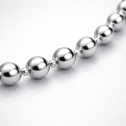 Macro view highlighting the smooth spherical beads and reflective silver tone finish of the necklace.
