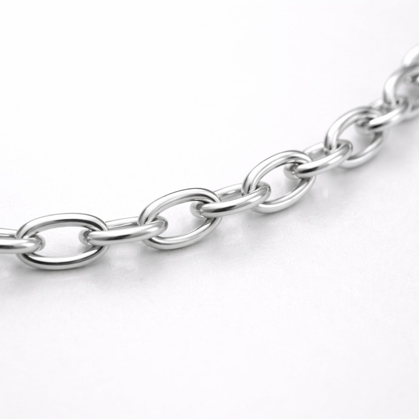 Studio view of a fine cable chain necklace with evenly spaced oval links in a polished silver tone finish.