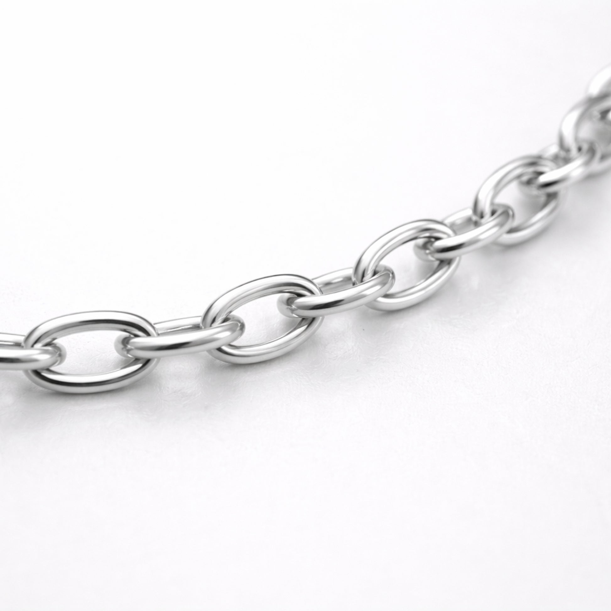 Studio view of a fine cable chain necklace with evenly spaced oval links in a polished silver tone finish.
