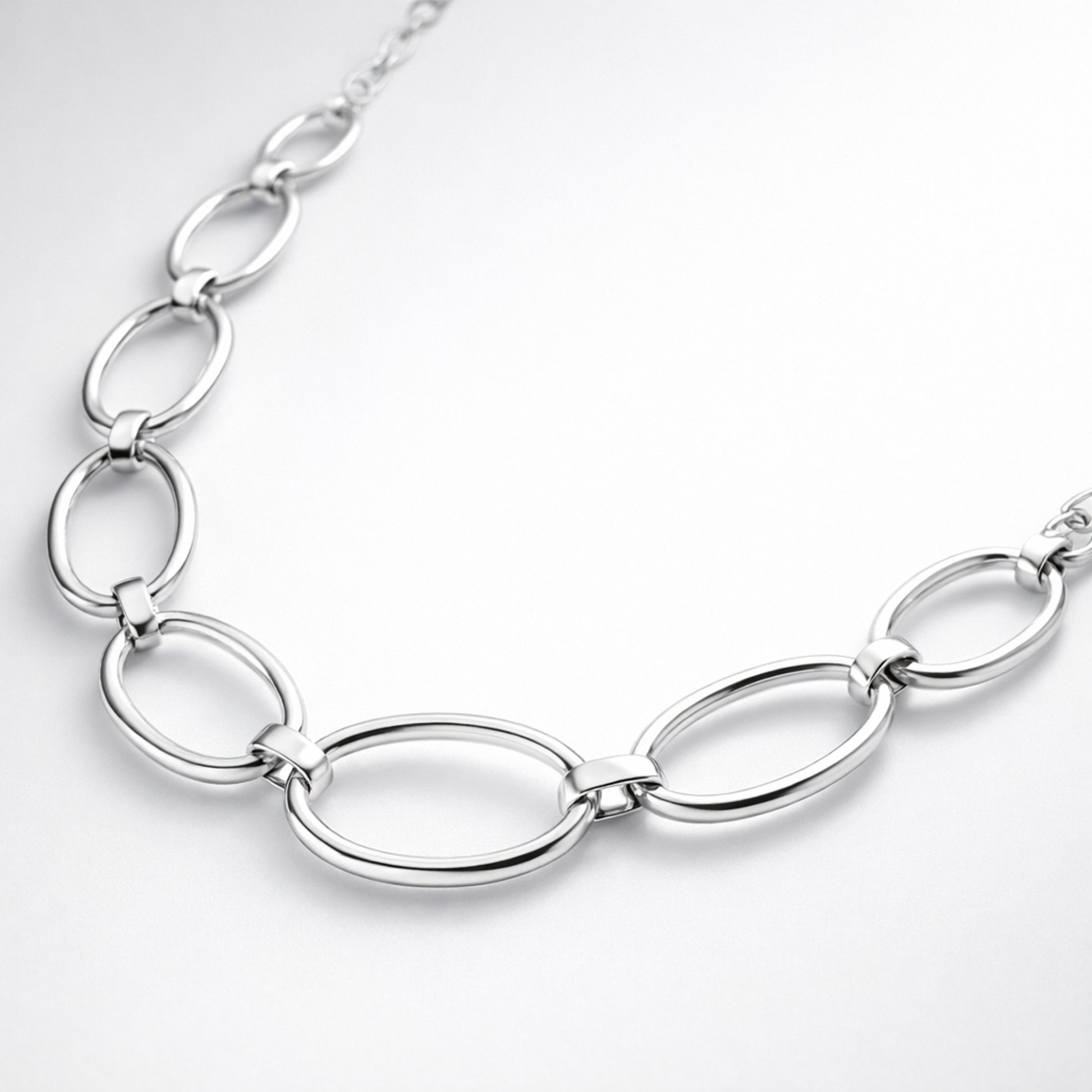 Angled studio view showing the elongated oval links and smooth silver tone finish of the necklace.