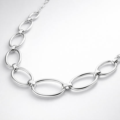 Angled studio view showing the elongated oval links and smooth silver tone finish of the necklace.