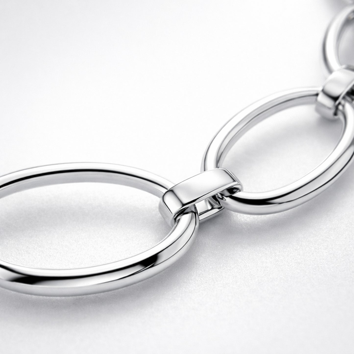 Close up detail highlighting the oval link structure and polished silver tone surface.