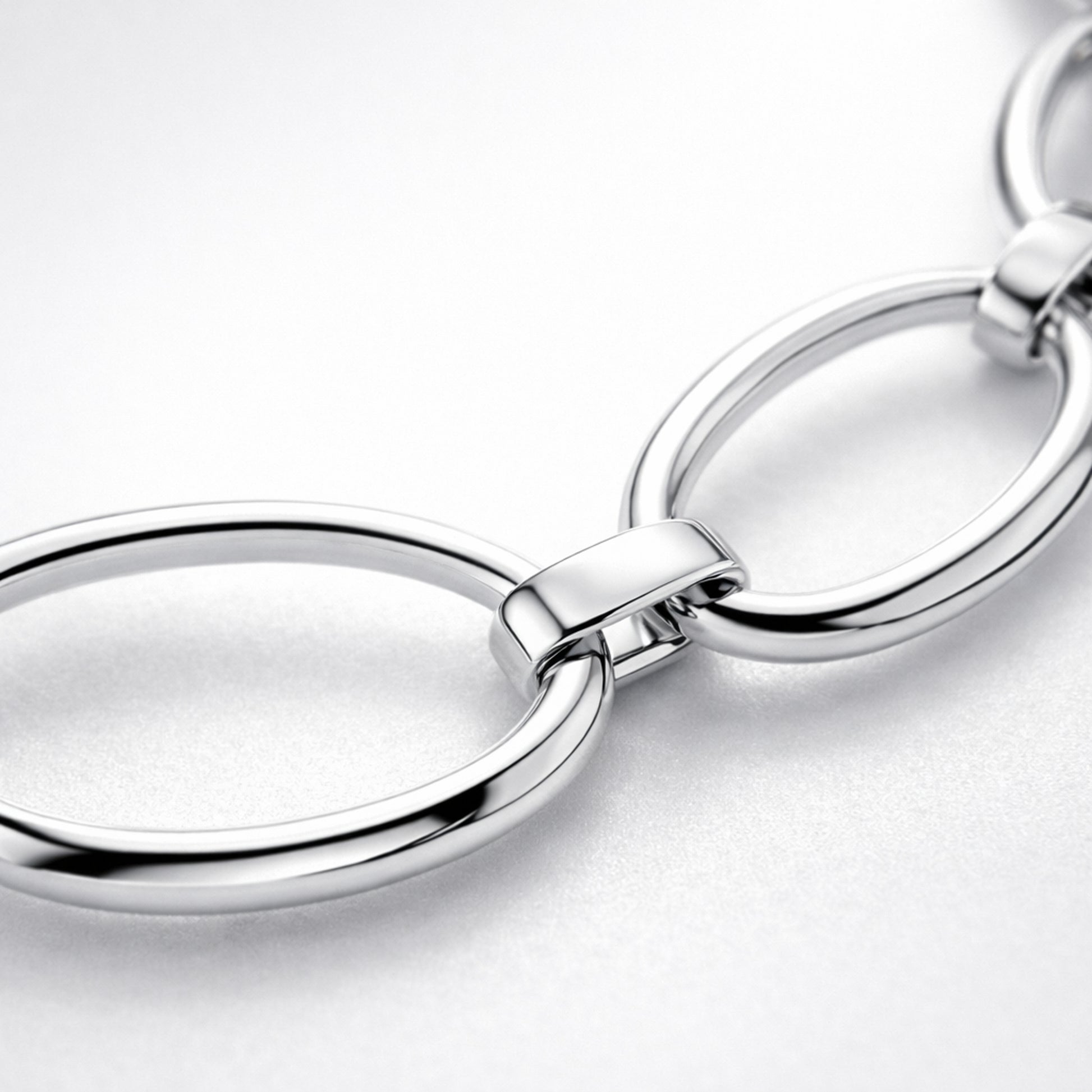 Close up detail highlighting the oval link structure and polished silver tone surface.