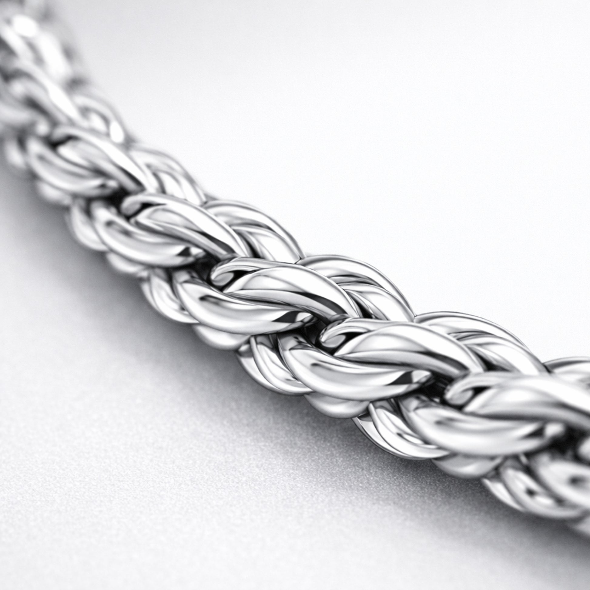 Close up detail of the rope chain highlighting the braided oval link structure and smooth polished silver tone surface.