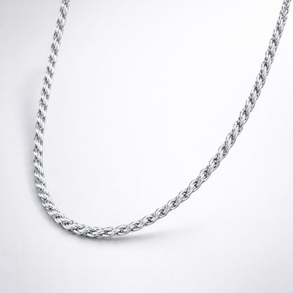 Studio view of the rope chain necklace arranged in a curved shape, showing a consistent braided pattern in silver tone.