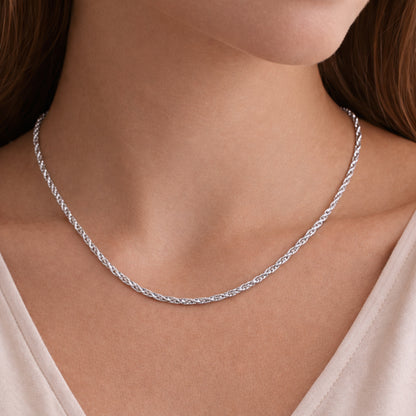 Angled view of the rope chain necklace worn on the neck, showcasing the braided twisted links and reflective silver tone surface.