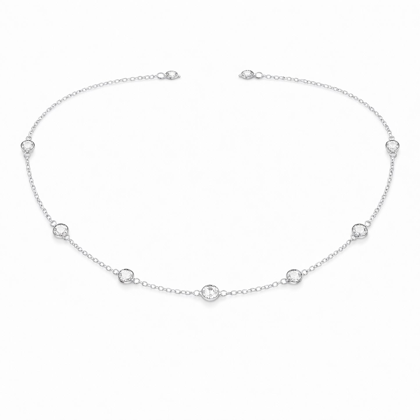 Angled studio view of the silver tone station necklace highlighting the refined chain links and round bezel set stone details.