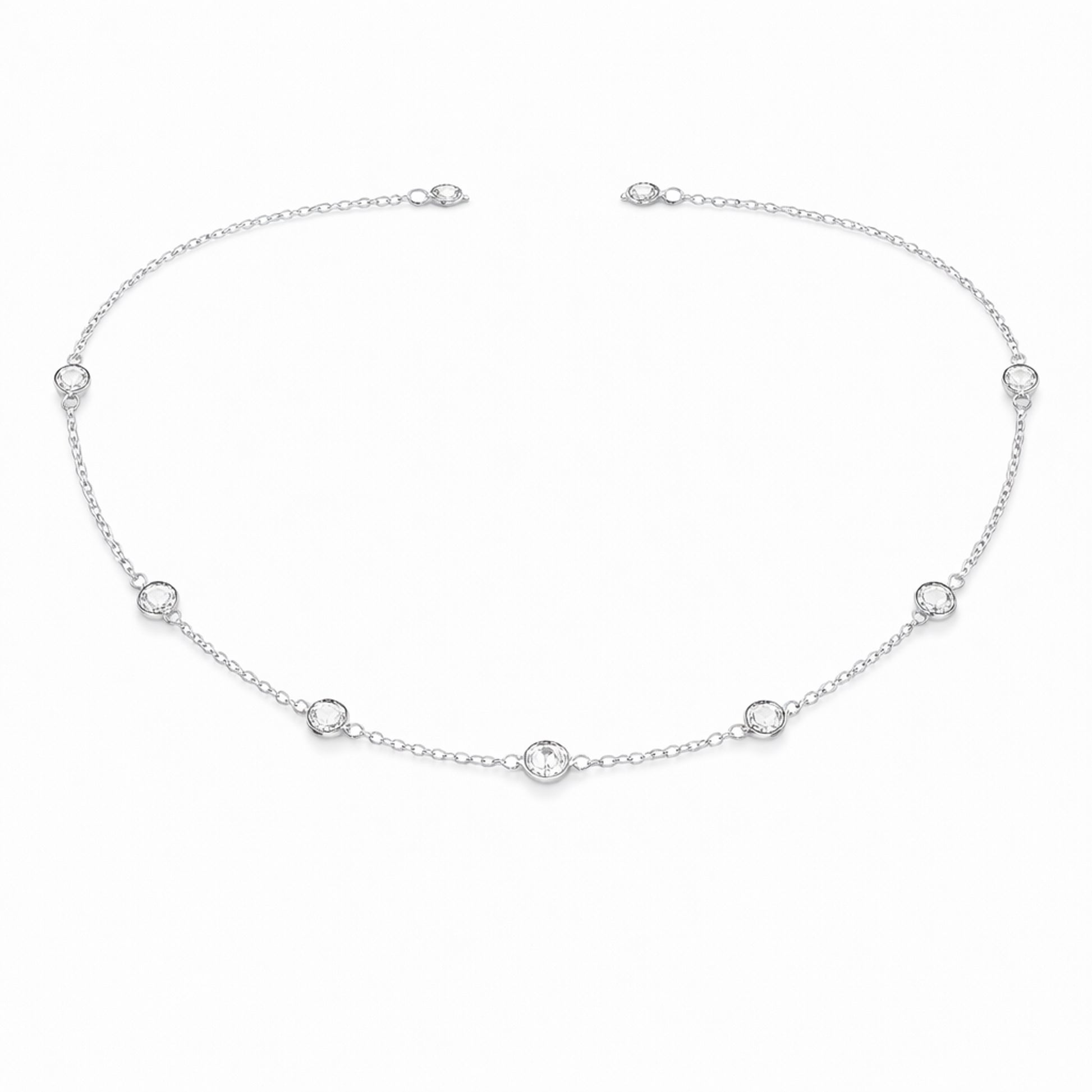 Angled studio view of the silver tone station necklace highlighting the refined chain links and round bezel set stone details.