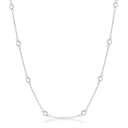 Front facing studio view of a silver tone station necklace featuring evenly spaced bezel set stones along a delicate chain.