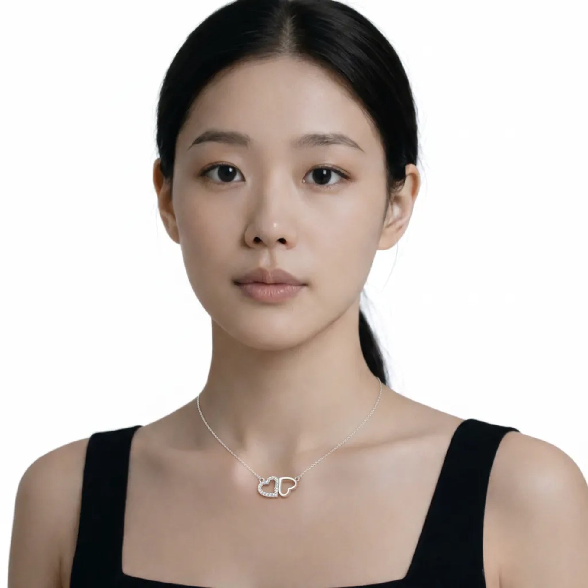 Model shot captures a silver tone double heart cubic zirconia pendant, styled with a black square-neck dress so the pendant stays centered at the neckline.