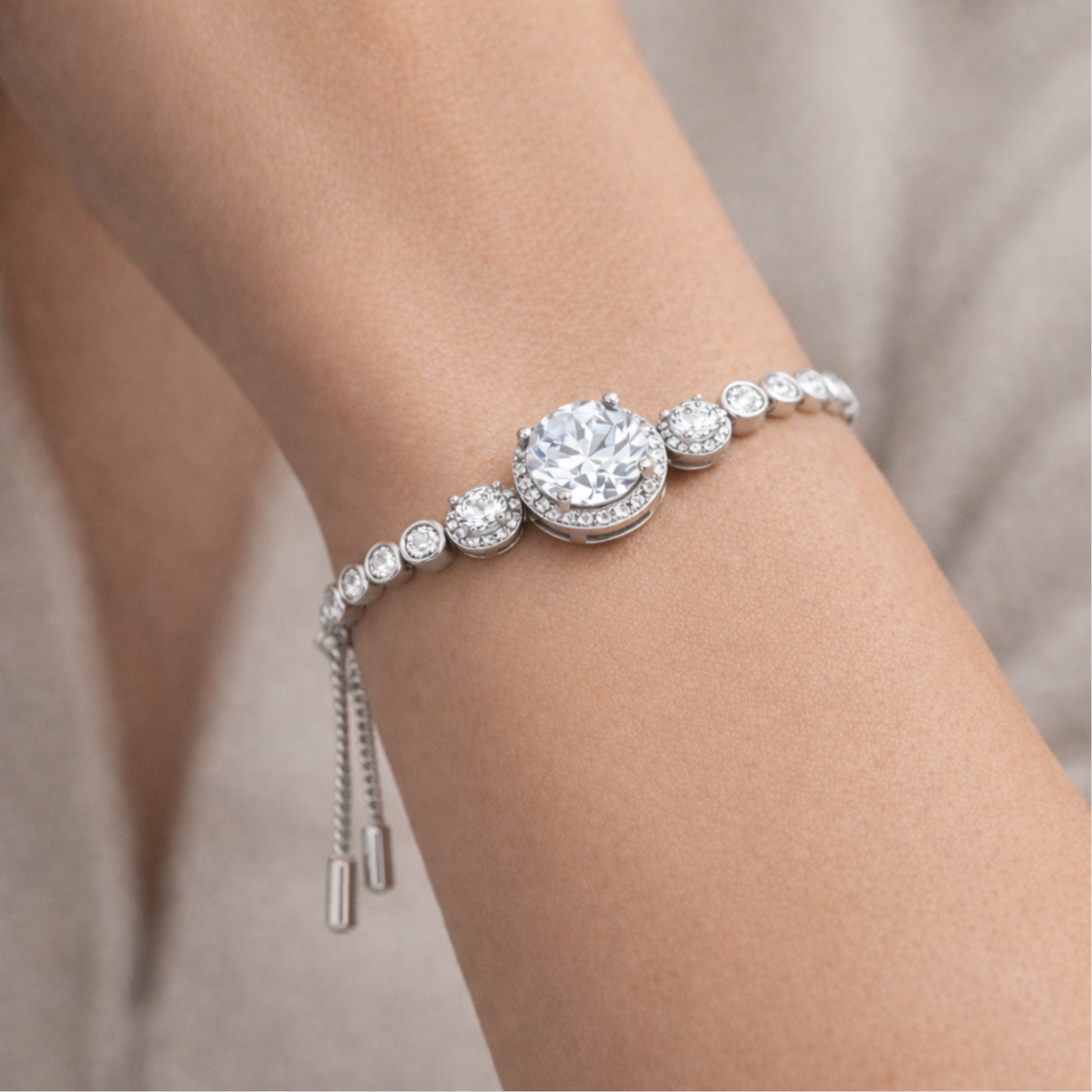 Slider bracelet worn on the wrist featuring a central halo design with cubic zirconia stones.