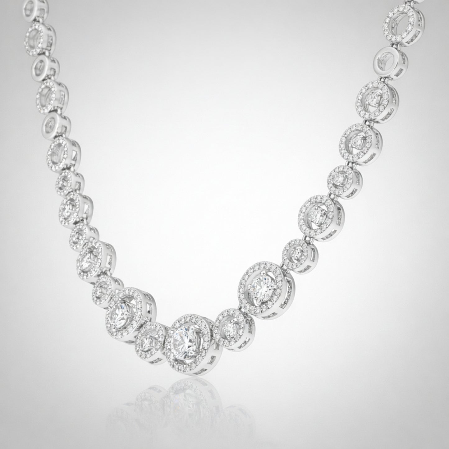 Angled studio view of a halo style silver tone necklace emphasizing the symmetrical stone arrangement.