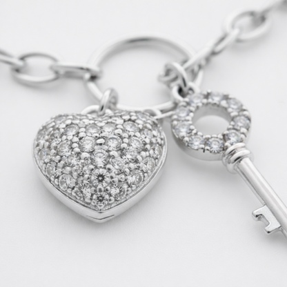 Close up view of the heart charm with cubic zirconia stones, showing the polished rhodium plated brass surface.