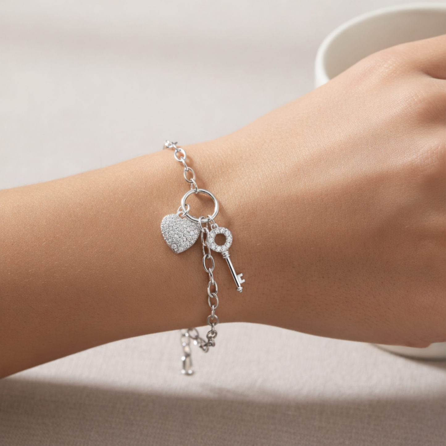 Heart and key charm bracelet worn on the wrist, illustrating fit, size and elegant everyday appearance.