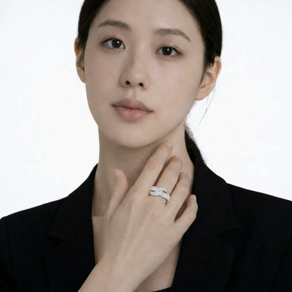Model shot captures a silver tone infinity pav cubic zirconia ring, styled with a short-sleeve black dress so the ring sparkles along the fingertips.