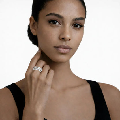 On-model portrait highlights a intertwined band ring with cubic zirconia, styled with a black sleeveless top so the ring sparkles along the fingertips.