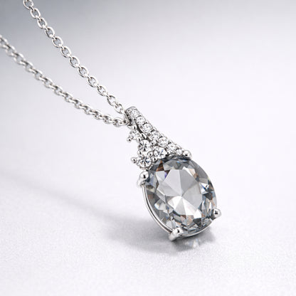 Detail view highlighting the side profile of the pear cut cubic zirconia pendant and the silver tone setting with small accent stones.