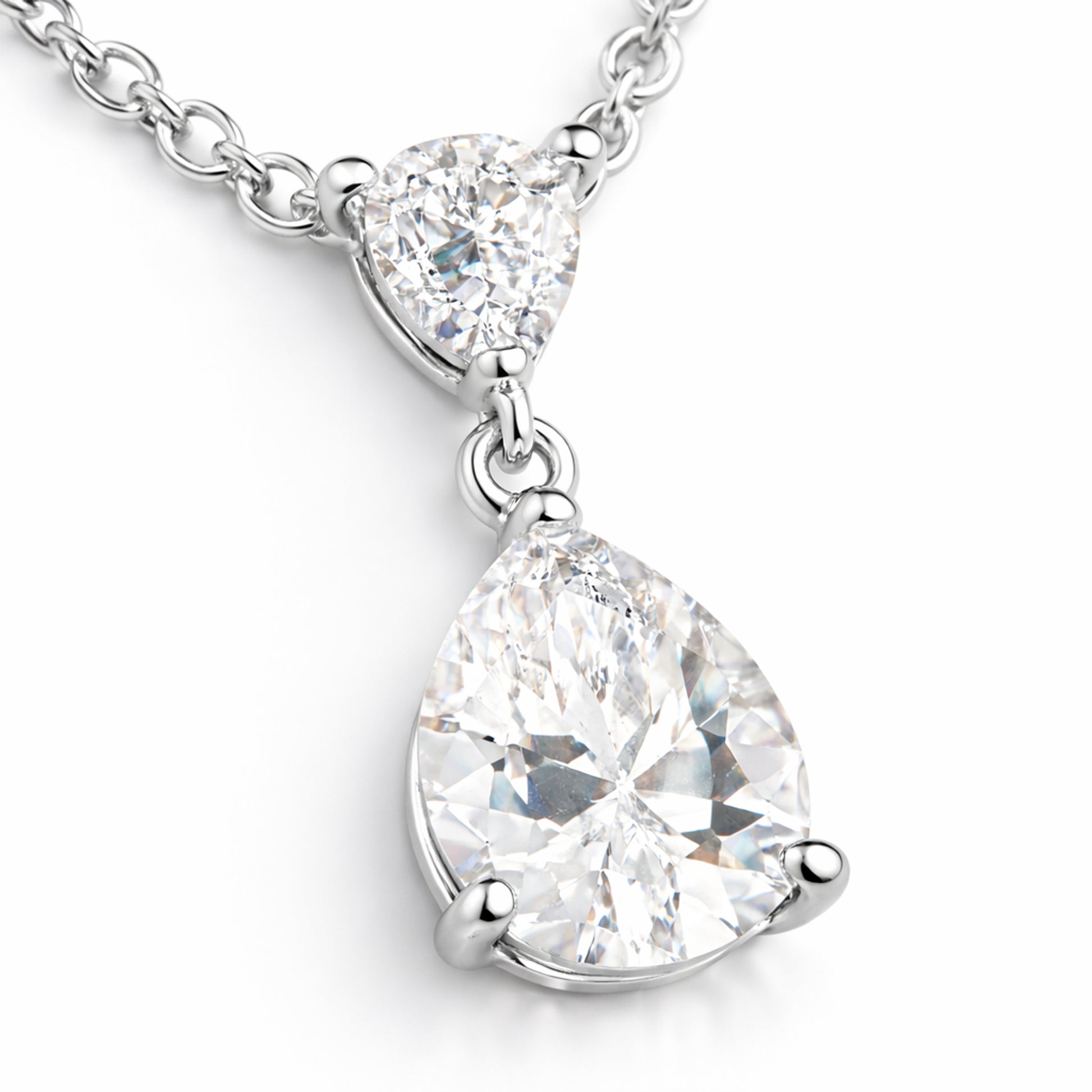 Close up view of the pear shaped cubic zirconia pendant highlighting the faceted stones and polished silver tone prong setting.