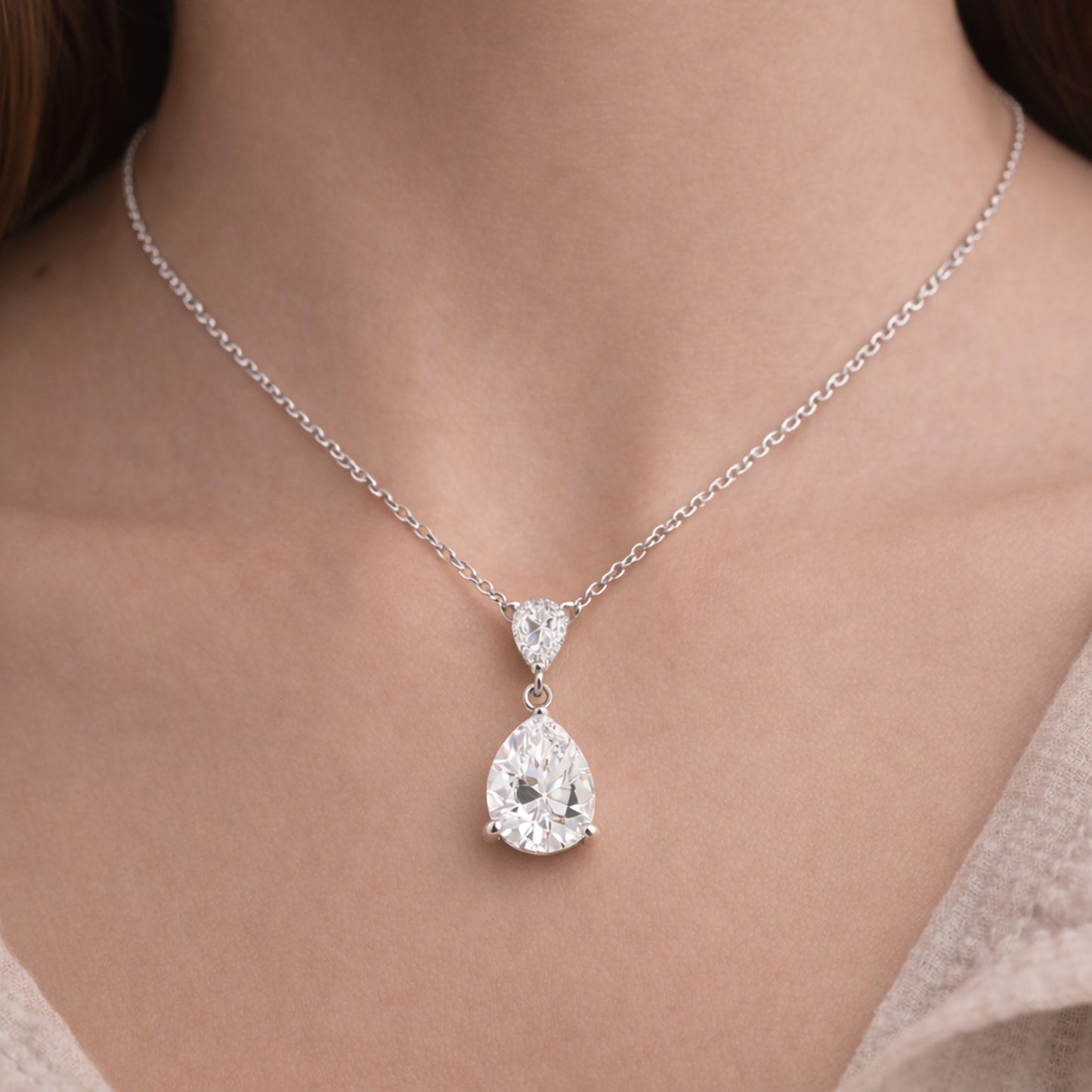 Worn view of the pear shaped drop pendant in silver tone showing scale and elegant proportions.