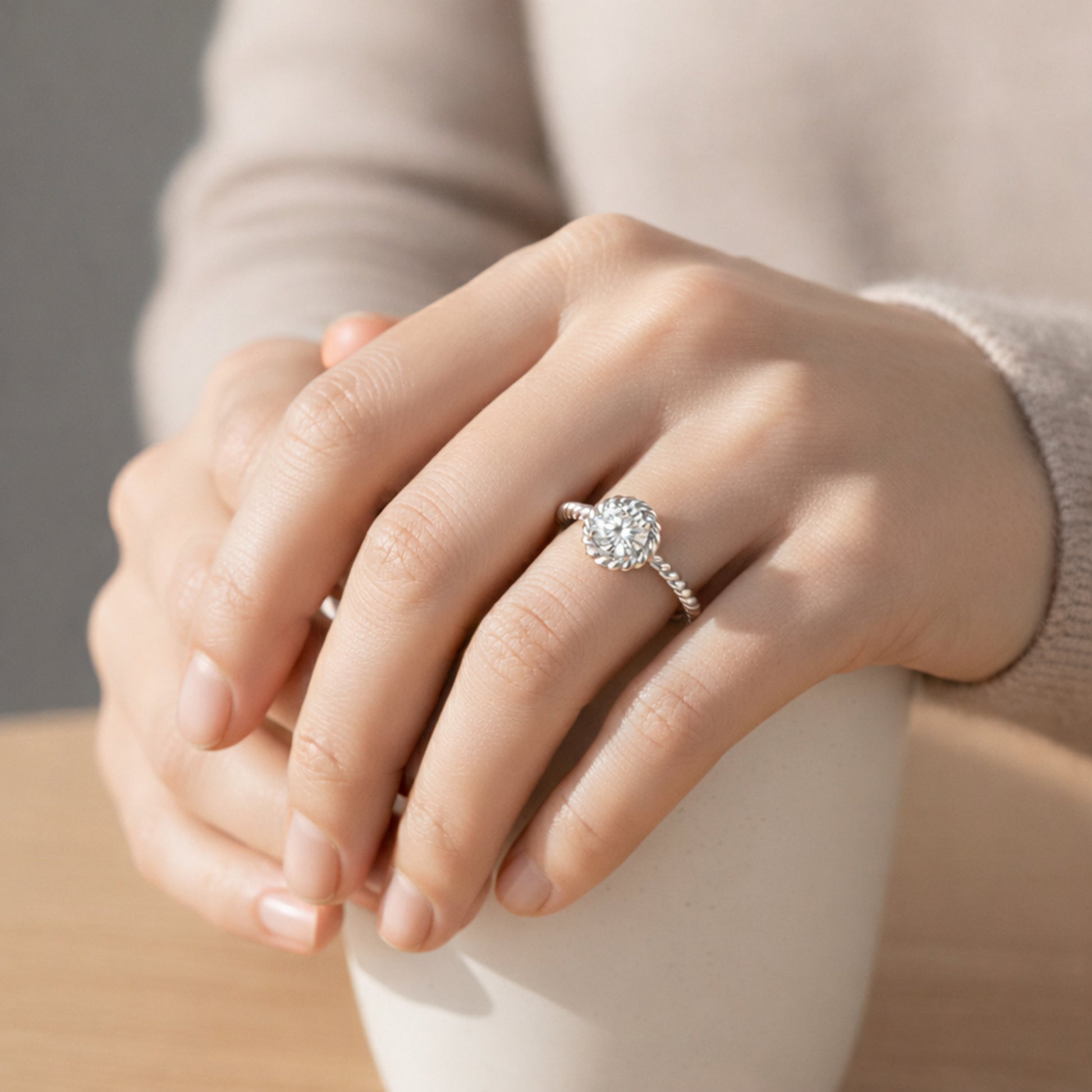 Worn view of the rope style solitaire cubic zirconia ring in silver tone finish, shown on the finger to illustrate scale.
