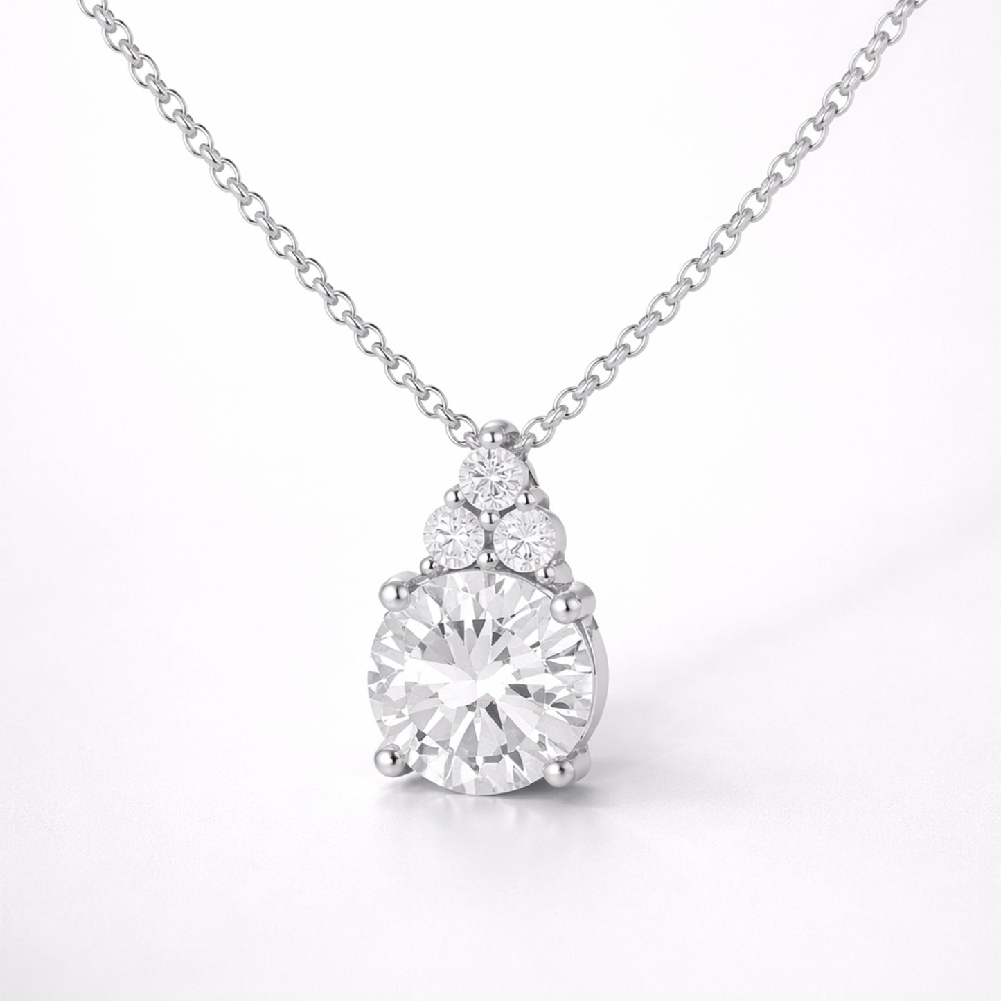 Studio view of a round cut cubic zirconia pendant featuring a central stone with smaller accent stones above.