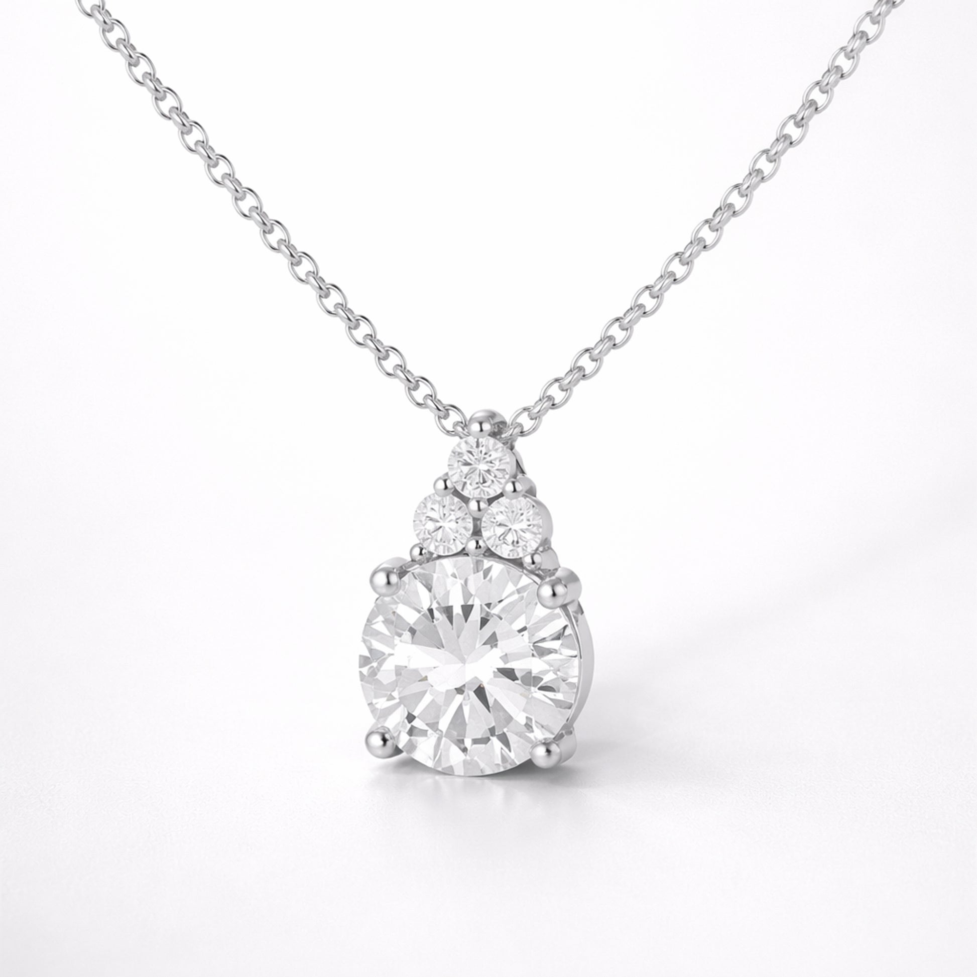 Studio view of a round cut cubic zirconia pendant featuring a central stone with smaller accent stones above.