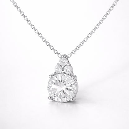 Studio view of a round cut cubic zirconia pendant featuring a central stone with smaller accent stones above.