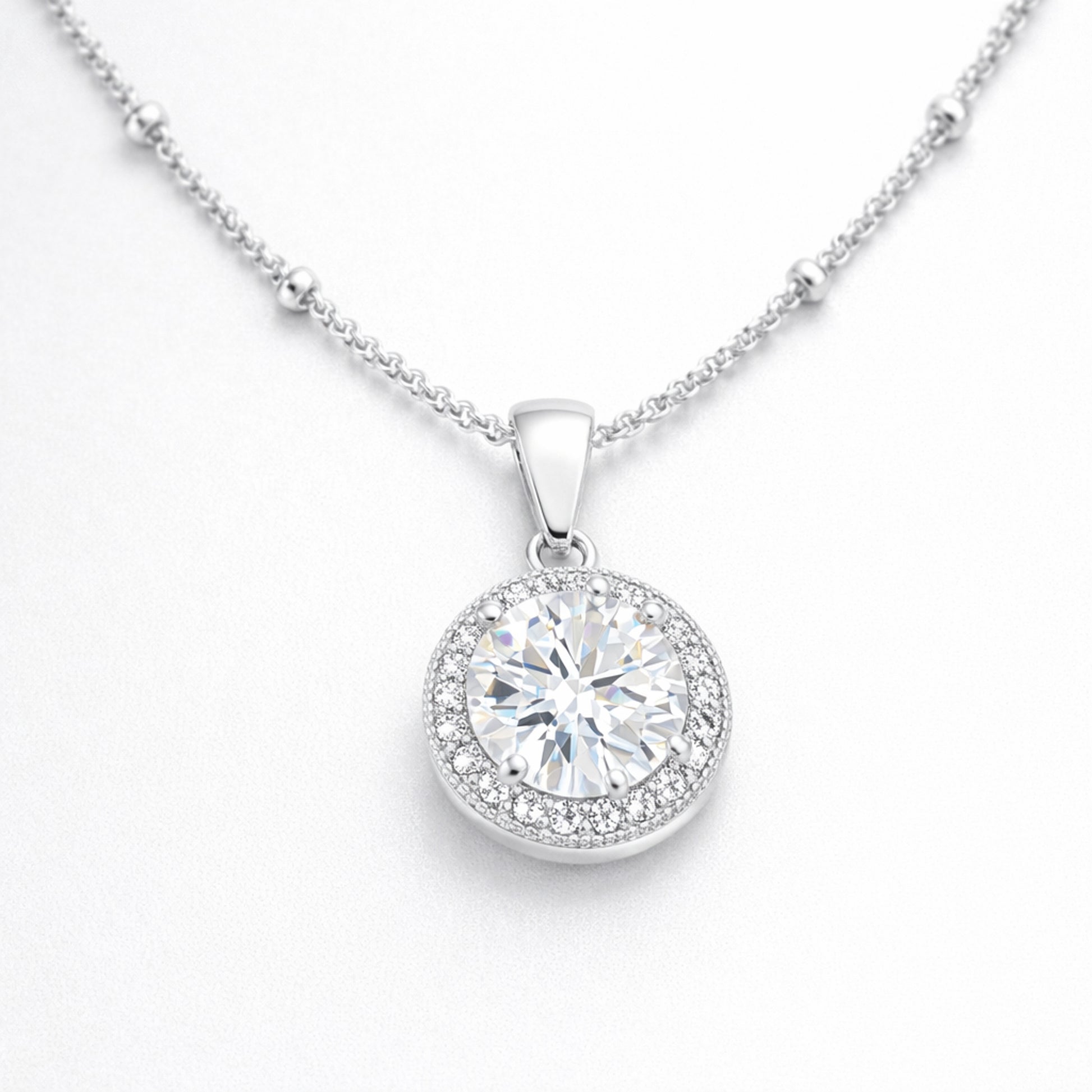 Angled studio view of the round halo pendant highlighting the prong set center stone and surrounding cubic zirconia halo.