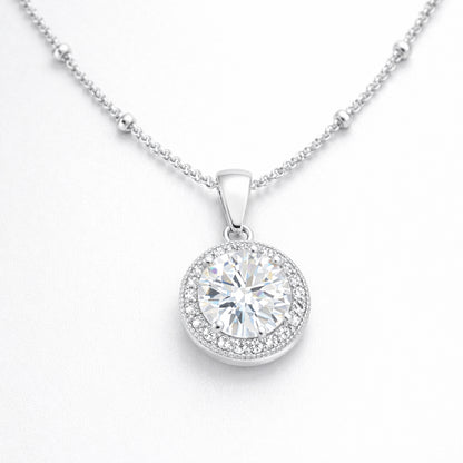 Angled studio view of the round halo pendant highlighting the prong set center stone and surrounding cubic zirconia halo.