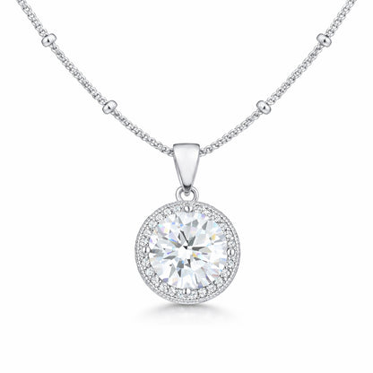 Studio view of a round halo pendant featuring a central cubic zirconia stone surrounded by a halo of smaller stones in silver tone.