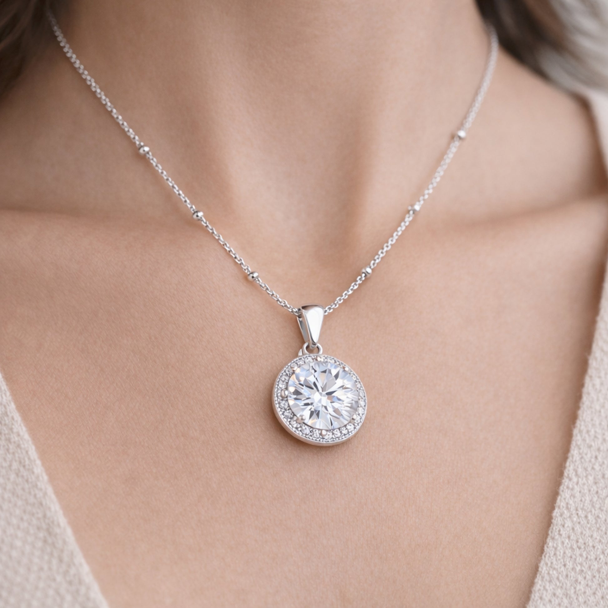 Worn view of the round halo cubic zirconia pendant showing scale and centered proportions when worn.