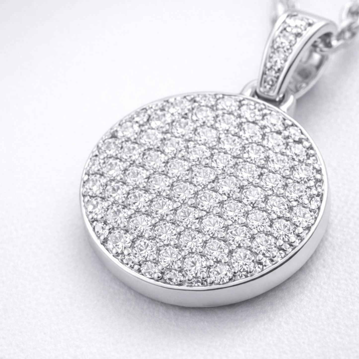 Close up view of the round pavé cubic zirconia pendant highlighting the detailed stone setting and smooth silver tone finish.