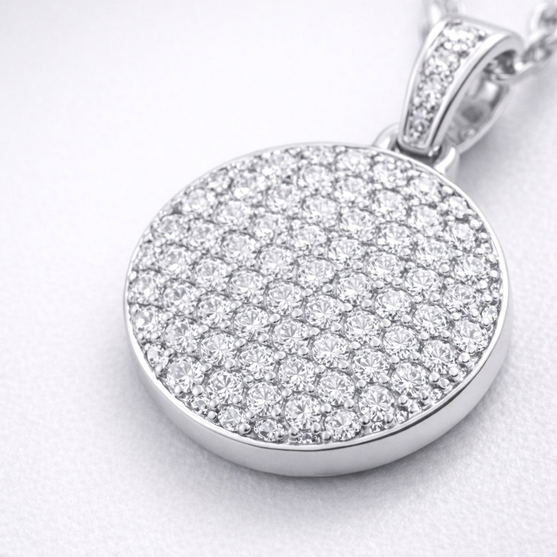 Close up view of the round pavé cubic zirconia pendant highlighting the detailed stone setting and smooth silver tone finish.