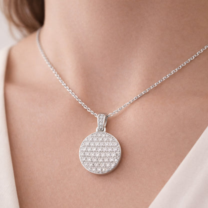 Worn view of the round pavé cubic zirconia pendant showing how the pendant sits and reflects light.