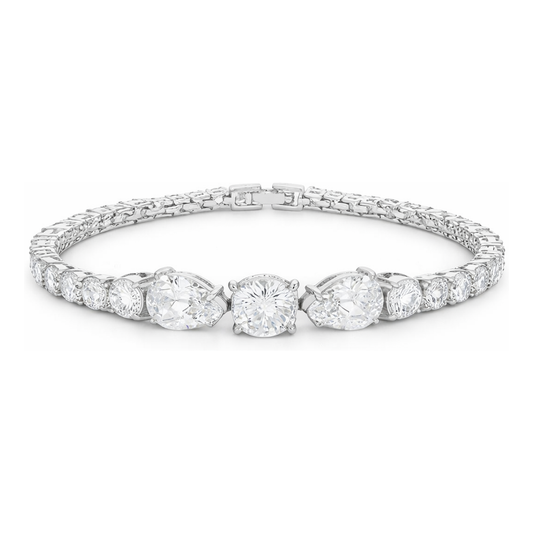 Studio view of a tennis bracelet featuring a central three-stone arrangement with larger cubic zirconia stones, surrounded by a row of smaller stones in silver tone.