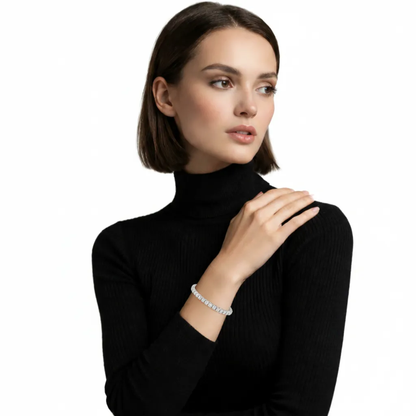 Model view highlights a classic cubic zirconia tennis bracelet with uniform round stones, resting over a black ribbed sleeve to showcase its continuous sparkle.