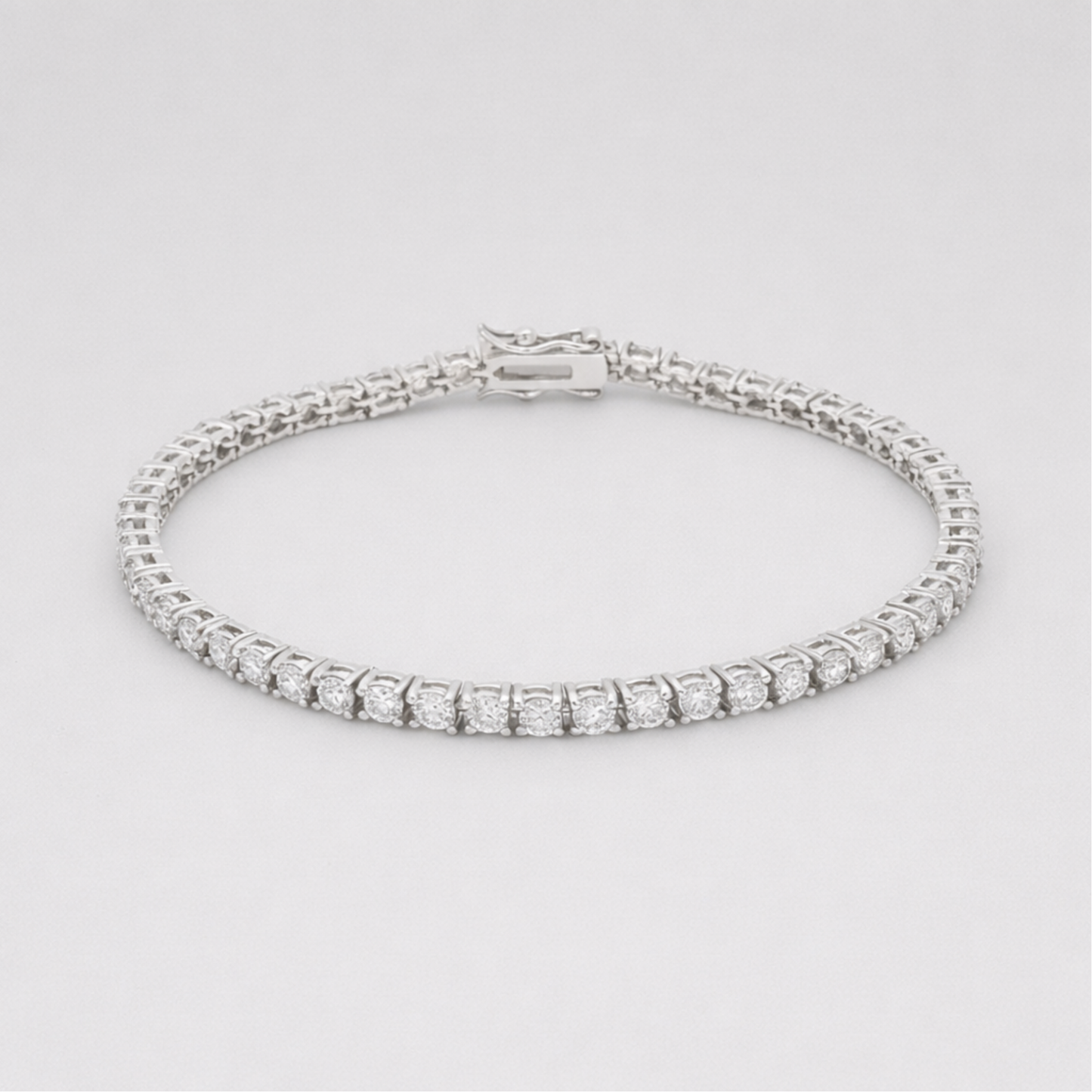 Studio view of a classic silver tone tennis bracelet featuring a continuous row of round cut cubic zirconia stones and a secure box clasp closure.
