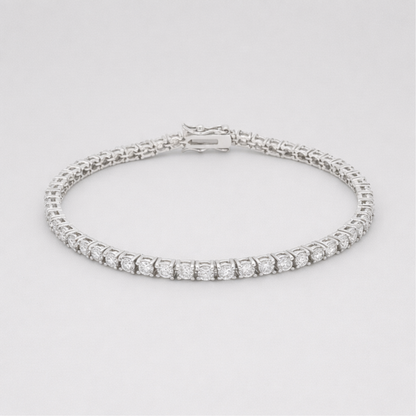 Studio view of a classic silver tone tennis bracelet featuring a continuous row of round cut cubic zirconia stones and a secure box clasp closure.