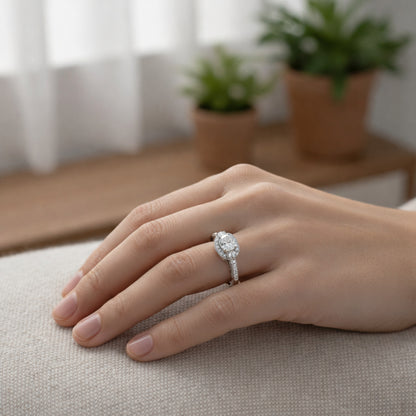 Worn view of a three stone halo cubic zirconia ring in silver tone finish, shown on the finger to illustrate proportions.